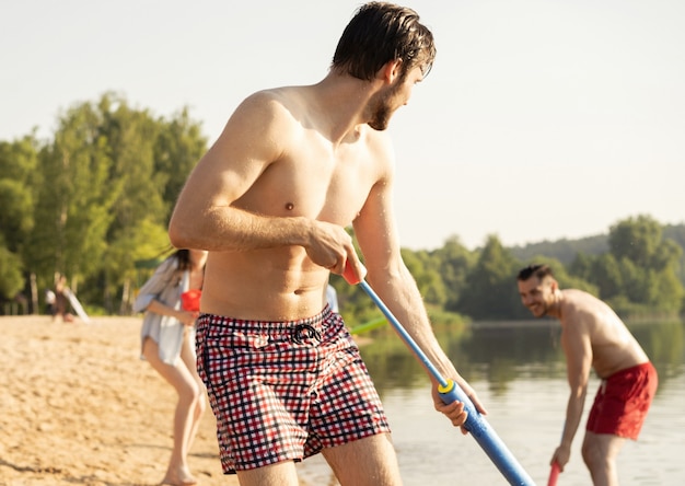 水鉄砲との戦いをしている幸せな友達-若者、夏のライフスタイルと休日のコンセプト