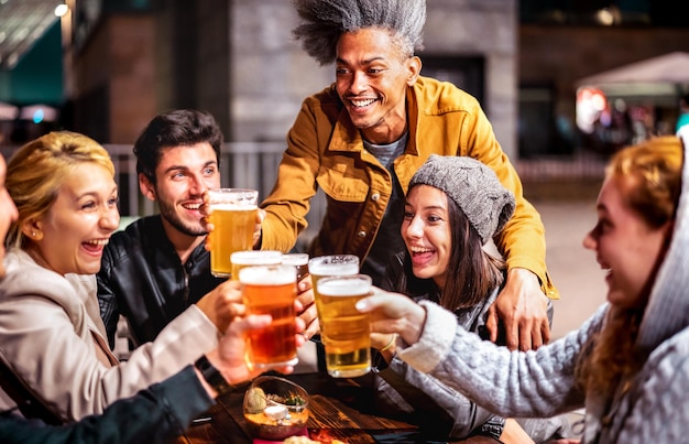 Happy friends drinking beer at brewery bar garden outdoors