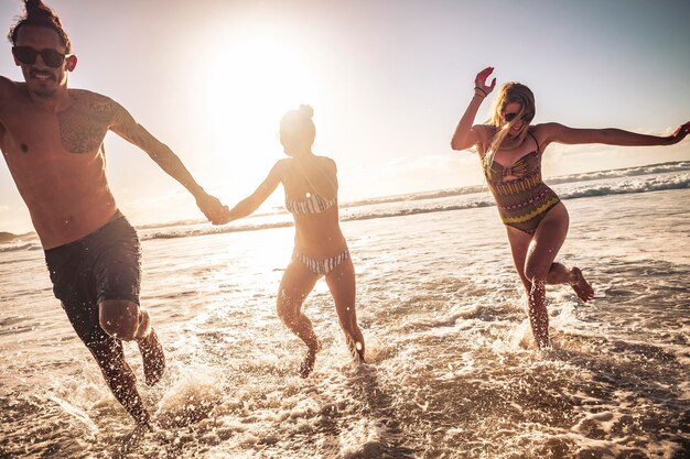 Photo happy friends enjoying on shore at beach