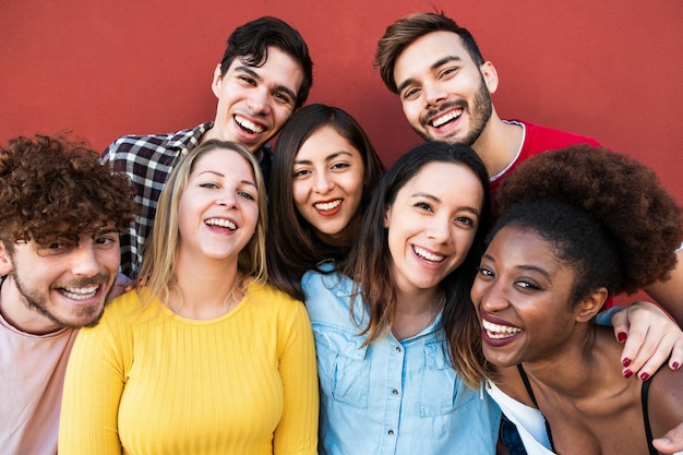 Happy friends from different races and culture laughing in front of phone camera - Young millennial people having fun together - Multiracial generation concept - Main focus on blond girl face