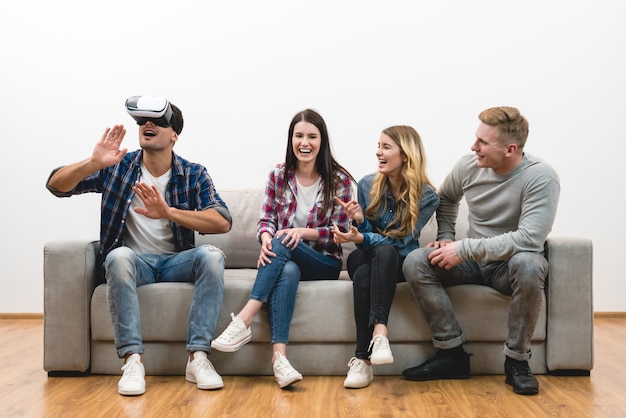 The happy friends fun with a virtual reality glasses on the white background