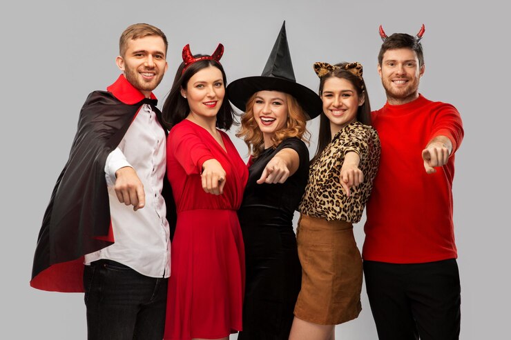 Photo happy friends in halloween costumes over grey