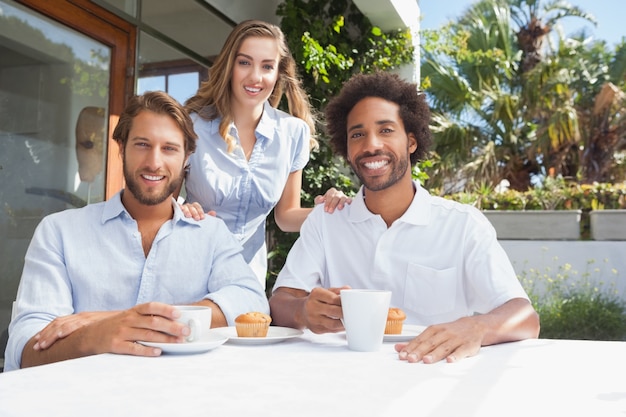 Amici felici che mangiano caffè insieme