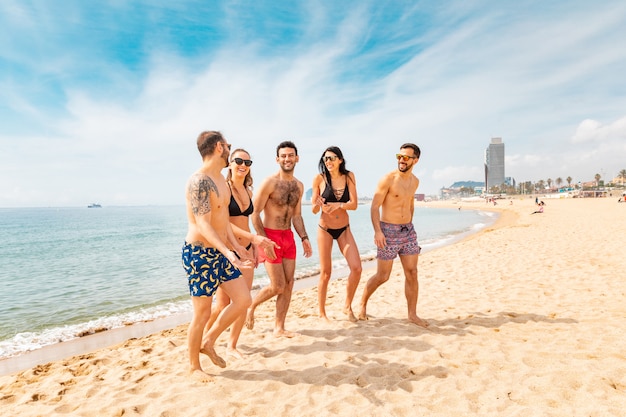 Foto amici felici che si divertono sulla spiaggia di barcellona