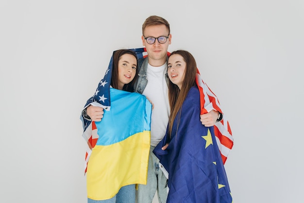 Happy friends holding flag Ukraine USA and EU