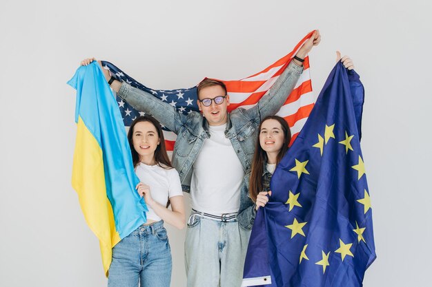 Happy friends holding flag Ukraine USA and EU