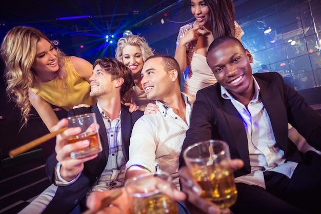 Happy friends holding a glass of alcohol