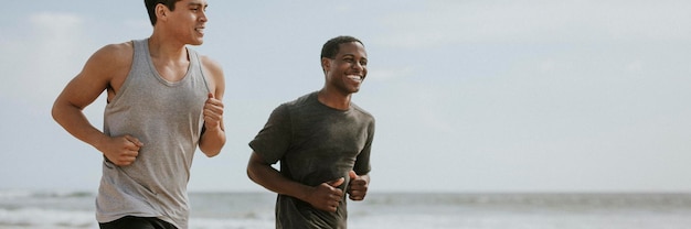 Happy friends jogging at the beach together