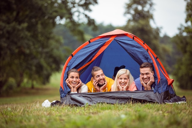 Happy friends lying in their tent