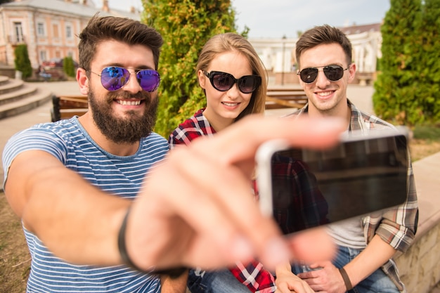 Happy friends make selfie on outdoors.