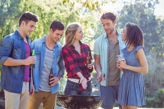 Photo happy friends in the park having barbecue