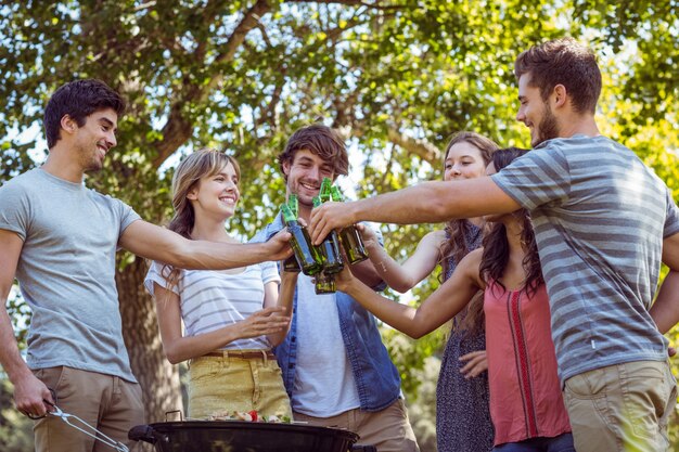 Photo happy friends in the park having barbecue