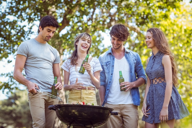 Happy friends in the park having barbecue