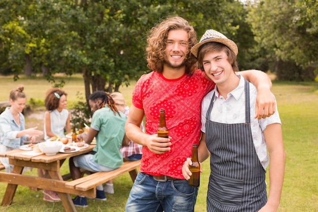 Photo happy friends in the park having barbecue