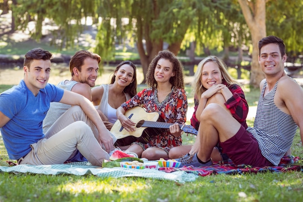 Happy friends in the park having picnic