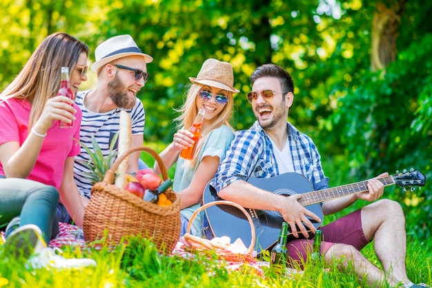 Happy friends in the park having picnic