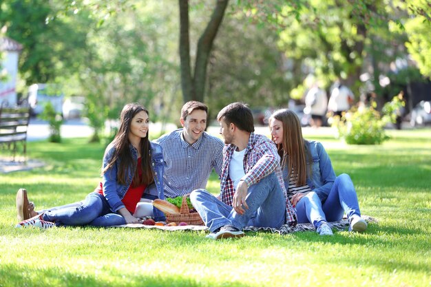 Happy friends on picnic in park