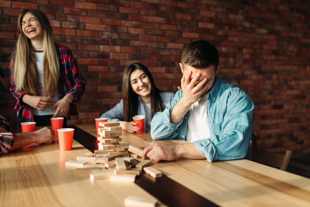 Happy friends plays table game at the table in cafe