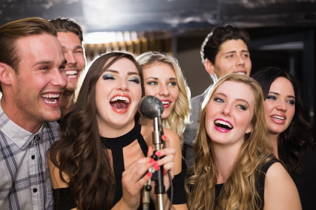 Foto amici felici che cantano insieme karaoke