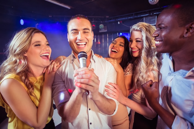 Amici felici che cantano al karaoke