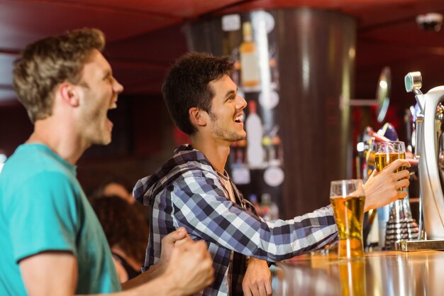 Happy friends sitting and drinking beer