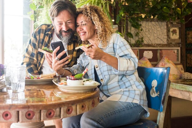 Photo happy friends sitting on table at home