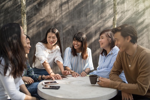 Happy friends sitting at table