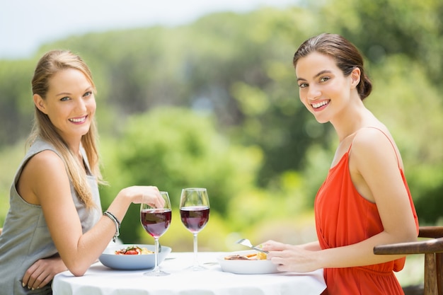 Happy friends smiling while having food in the restaurant