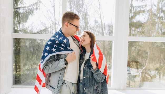 Happy friends spending time holding american flag