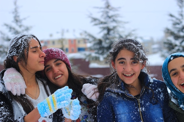 Photo happy friends standing against sky during winter