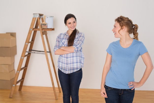 Happy friends standing in a new house