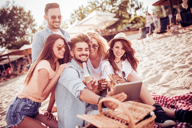 Amici felici che prendono selfie sulla spiaggia