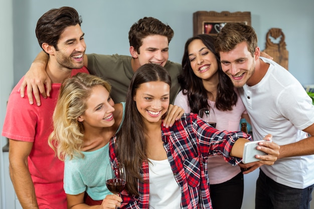 Happy friends taking selfie at home