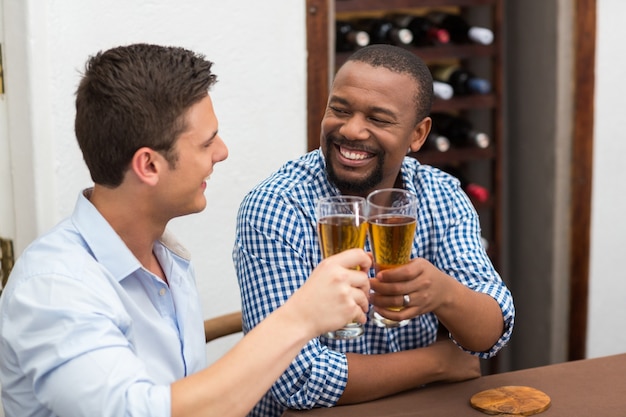 幸せな友達のビールのグラスを乾杯