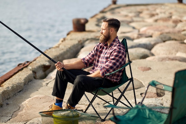 happy friends with fishing rods on pier