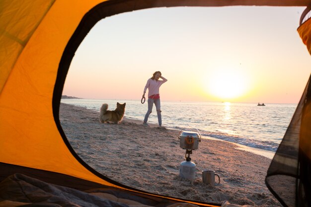 Happy fun weekend by the sea - girl playing with a dog on the beach. summer