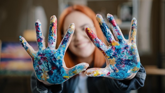 Happy funny caucasian redhaired woman in eyeglasses girl painter wear glasses looking at camera