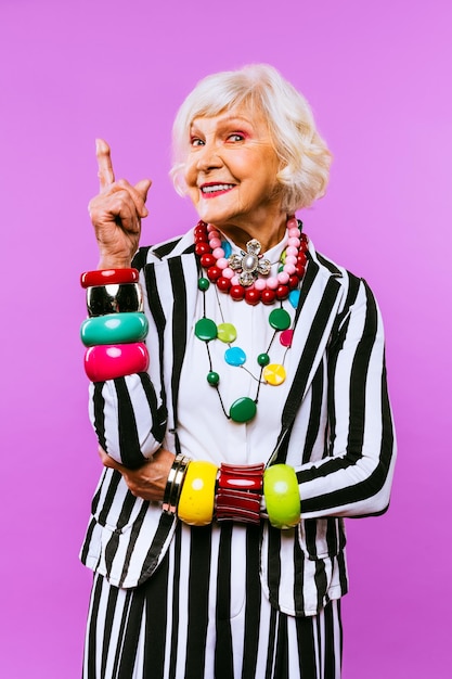 Happy and funny cool old lady with fashionable clothes portrait on colored background  Youthful grandmother with extravagant style concepts about lifestyle seniority and elderly people