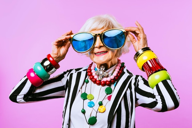 Felice e divertente vecchia signora con vestiti alla moda ritratto su sfondo colorato nonna giovanile con concetti di stile stravaganti sull'anzianità di vita e sugli anziani