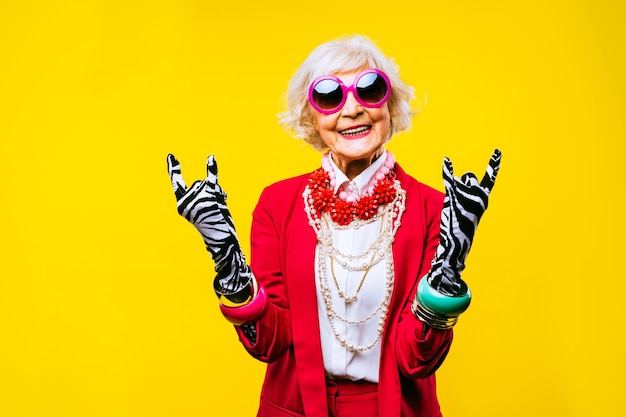 Happy and funny cool old lady with fashionable clothes portrait on colored background youthful grandmother with extravagant style concepts about lifestyle seniority and elderly people