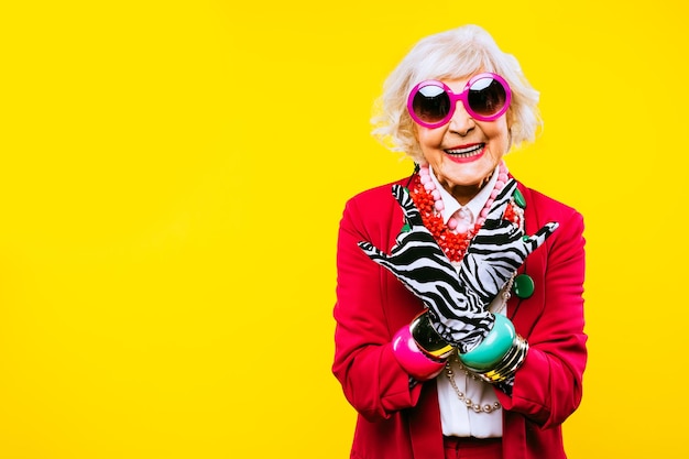 Happy and funny cool old lady with fashionable clothes portrait on colored background  Youthful grandmother with extravagant style concepts about lifestyle seniority and elderly people