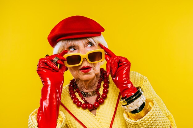 Happy and funny cool old lady with fashionable clothes portrait on colored background  Youthful grandmother with extravagant style concepts about lifestyle seniority and elderly people