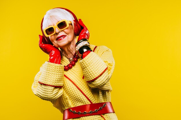 Happy and funny cool old lady with fashionable clothes portrait on colored background  Youthful grandmother with extravagant style concepts about lifestyle seniority and elderly people