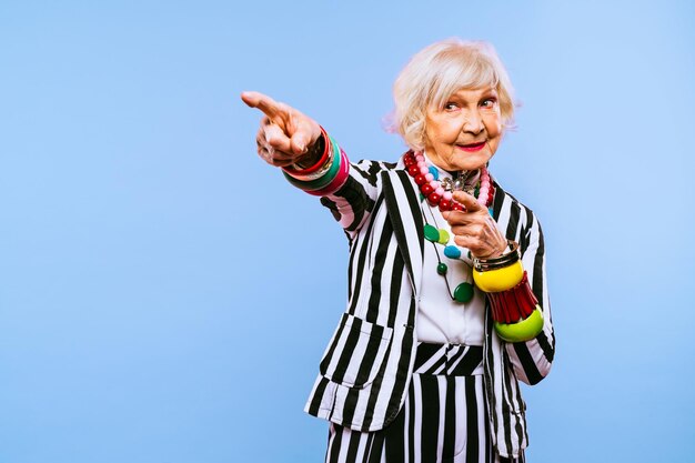 Foto felice e divertente vecchia signora con vestiti alla moda ritratto su sfondo colorato nonna giovanile con concetti di stile stravaganti sull'anzianità di vita e sugli anziani