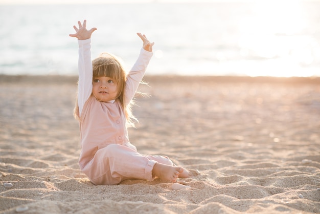 Счастливый смешной маленький ребенок, играющий на пляже