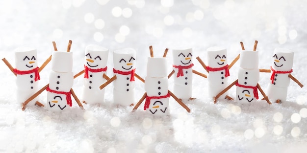 사진 행복한 재미있는 마시멜로 스노우맨은 눈에서 즐거운 크리스마스 배너를 가지고 있습니다.