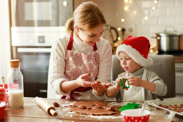 Happy funny mother and child son bake christmas cookies