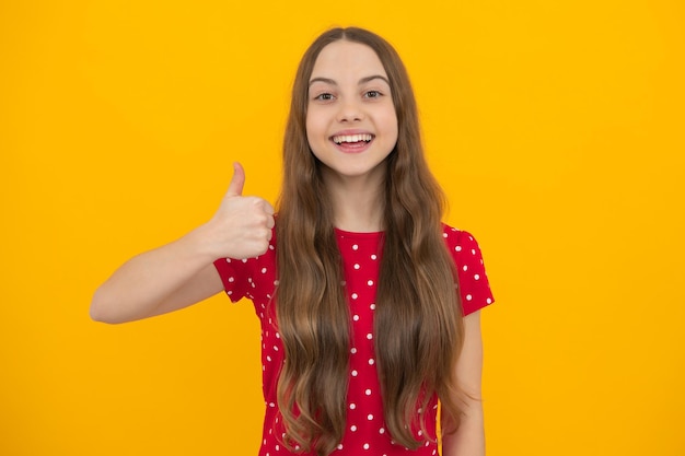 Happy funny teenager child girl show sight thumbs up and good luck