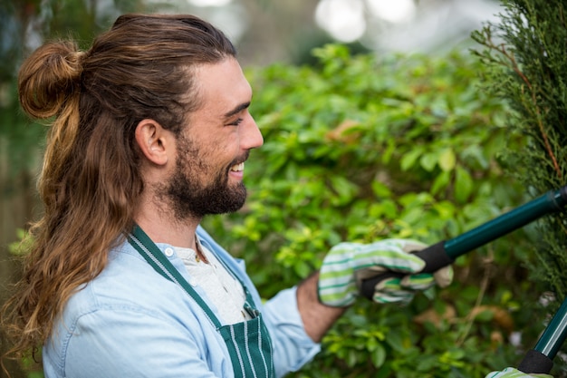 Photo happy gardener using hedge clippers at communicty garden