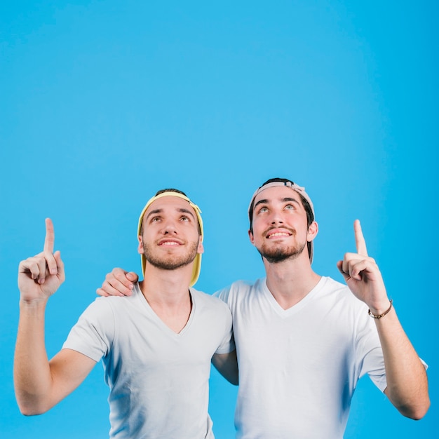 Photo happy gay couple cuddling and pointing up